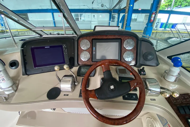 Slide: The Image of Helm of 2005 Sea Ray 500 Sundancer yacht with navigation controls and wooden steering wheel. - 22