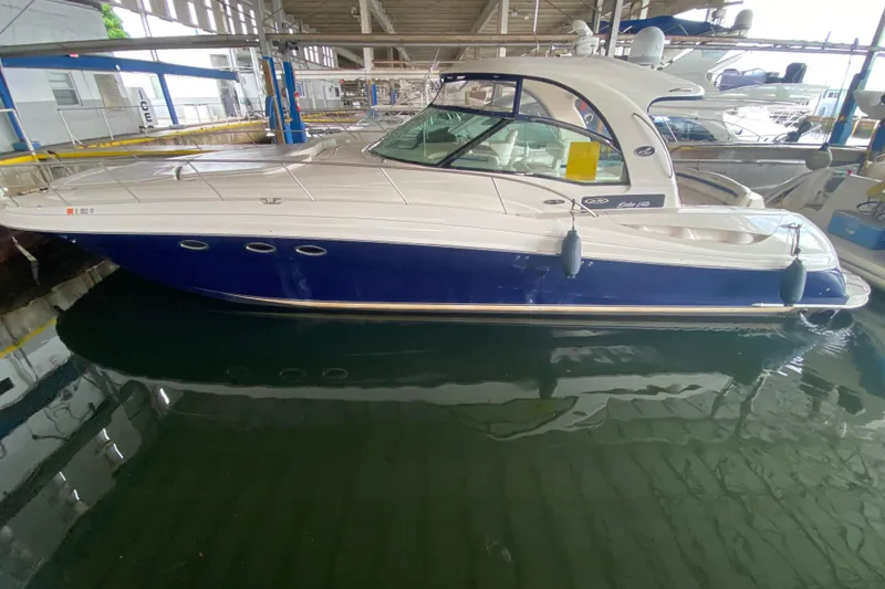 Slide: The Image of 2005 Sea Ray 500 Sundancer yacht docked in a marina, featuring sleek design and blue hull. - 3