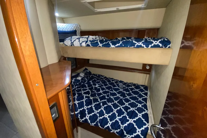 Slide: The Image of 2005 Sea Ray 500 Sundancer cabin with cozy bunk beds and nautical-themed bedding. - 33
