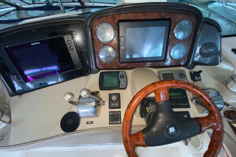 Slide: The Image of Helm of 2005 Sea Ray 500 Sundancer with navigation screens and wood-trimmed steering wheel. - 48