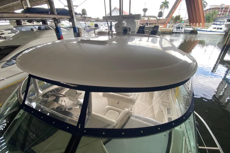 Slide: The Image of 2005 Sea Ray 500 Sundancer yacht docked in marina, showcasing helm and seating area. - 50