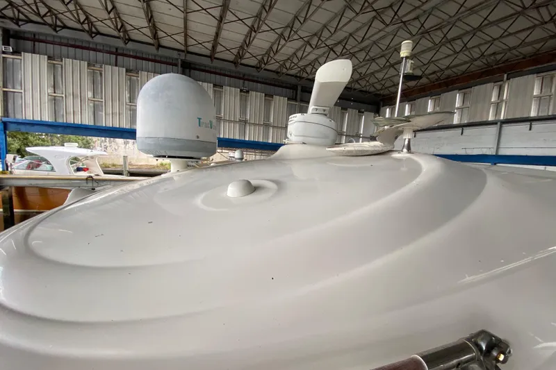 Slide: The Image of 2005 Sea Ray 500 Sundancer yacht roof with radar and satellite equipment in a marina. - 52