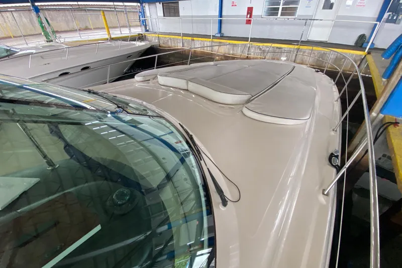 Slide: The Image of 2005 Sea Ray 500 Sundancer yacht docked indoors, showcasing sleek design and spacious deck. - 9