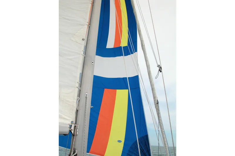 Slide: The Image of Colorful sail on a 1986 Catalina 36 yacht, featuring vibrant stripes against a clear sky. - 3