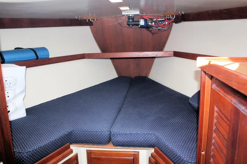 Slide: The Image of Interior cabin of a 1986 Catalina 36 sailboat with blue cushioned berth. - 35
