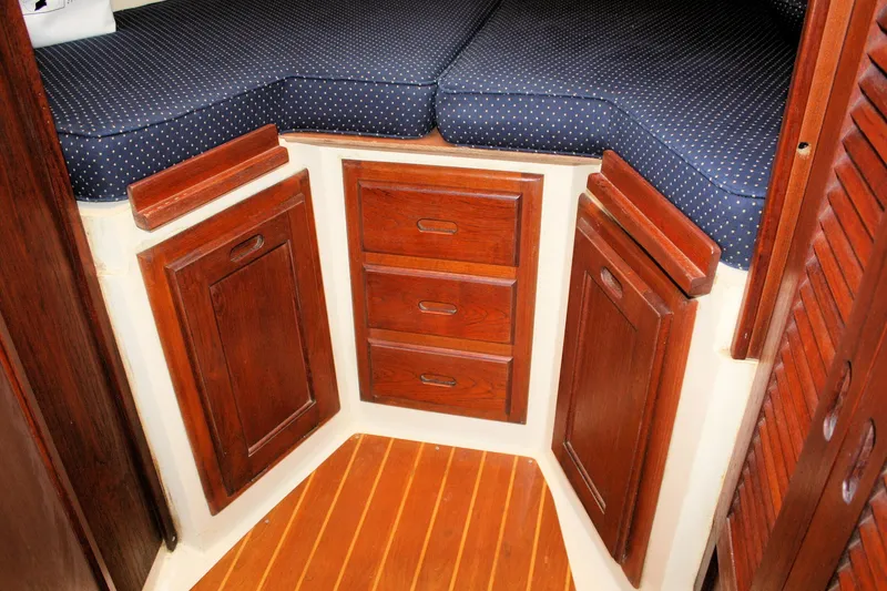 Slide: The Image of Interior of 1986 Catalina 36 sailboat with wooden cabinets and blue cushioned seating. - 37