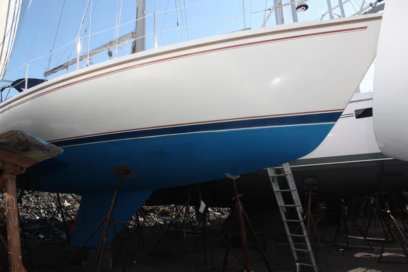 Slide: The Image of 1986 Catalina 36 sailboat on stands, blue hull, ladder nearby. - 4