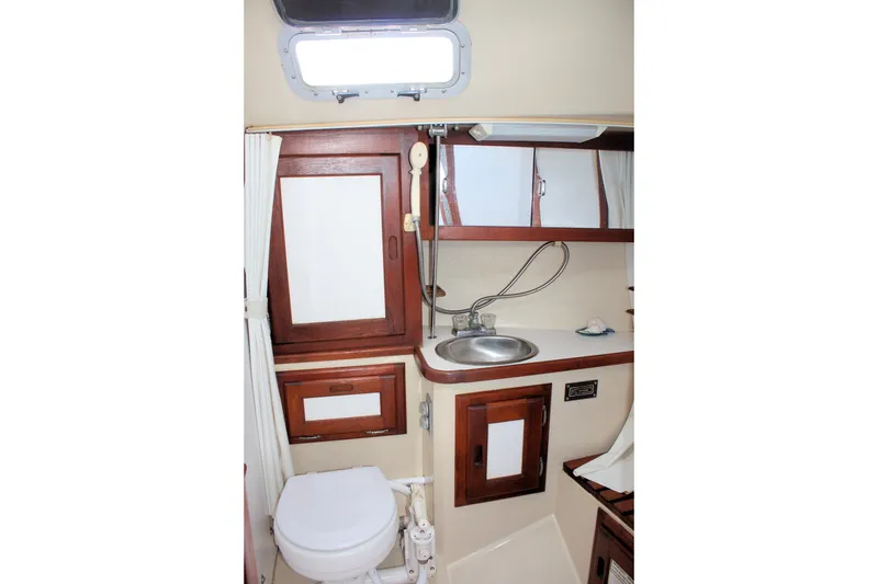 Slide: The Image of Interior of 1986 Catalina 36 sailboat bathroom with sink, toilet, and wooden cabinets. - 40