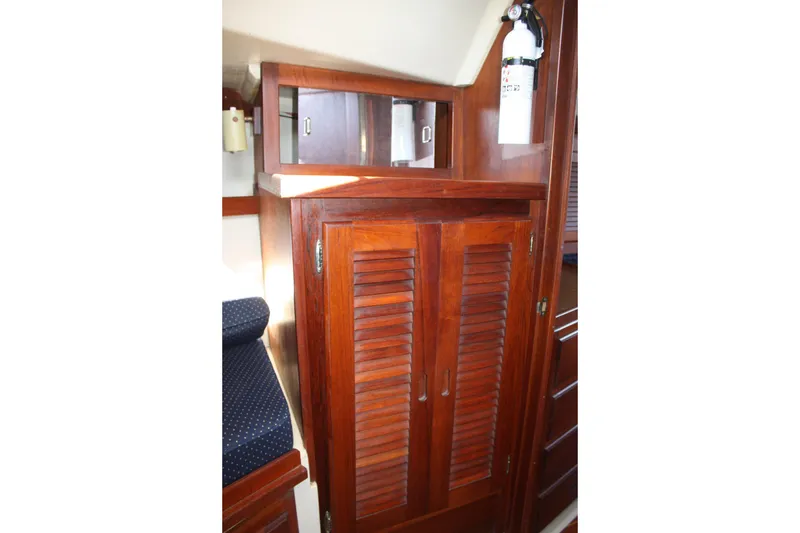 Slide: The Image of Interior of 1986 Catalina 36 sailboat featuring wooden cabinetry and fire extinguisher. - 42