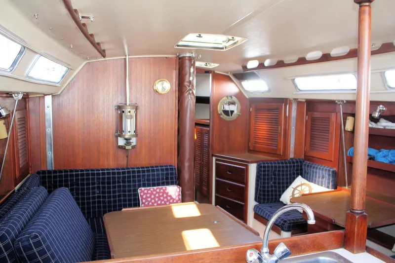 Slide: The Image of Interior of a 1986 Catalina 36 sailboat with wood paneling and blue seating. - 45