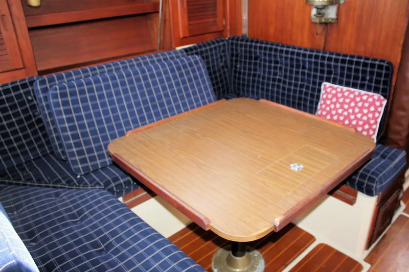 Slide: The Image of Interior of 1986 Catalina 36 sailboat with blue checkered seating and wooden table. - 46