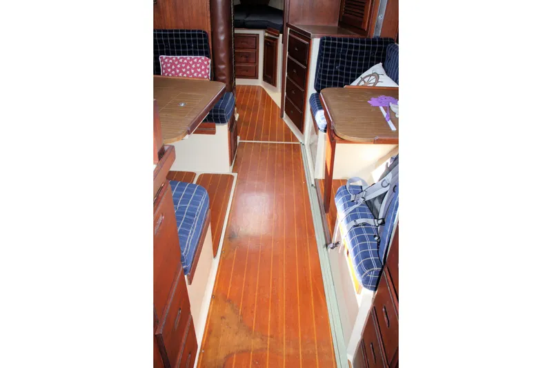 Slide: The Image of Interior of a 1986 Catalina 36 sailboat with wooden flooring and blue plaid seating. - 47