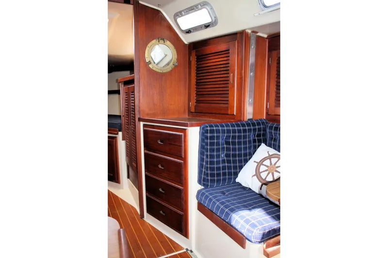 Slide: The Image of Interior of a 1986 Catalina 36 sailboat with wooden cabinetry and blue plaid seating. - 48