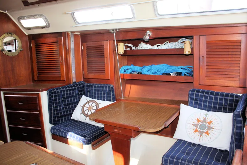 Slide: The Image of Interior of 1986 Catalina 36 sailboat with wooden cabinetry and nautical-themed cushions. - 49