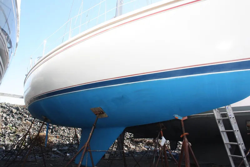 Slide: The Image of 1986 Catalina 36 sailboat on stands, showcasing blue hull and white upper deck. - 5