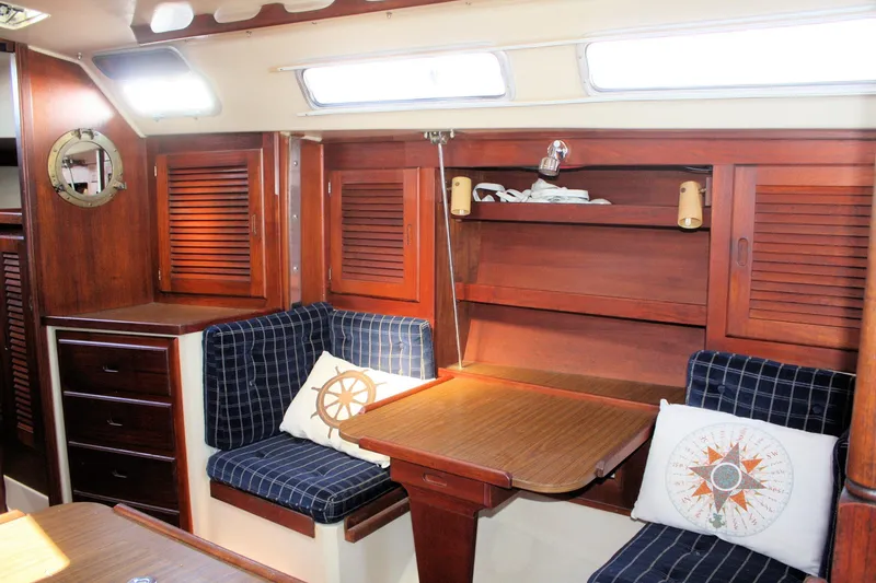 Slide: The Image of Interior of 1986 Catalina 36 sailboat with wooden cabinetry and nautical-themed cushions. - 50