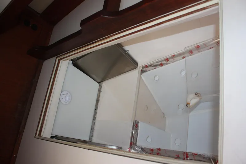 Slide: The Image of Interior storage compartment of a 1986 Catalina 36 sailboat, featuring wood trim and white panels. - 57