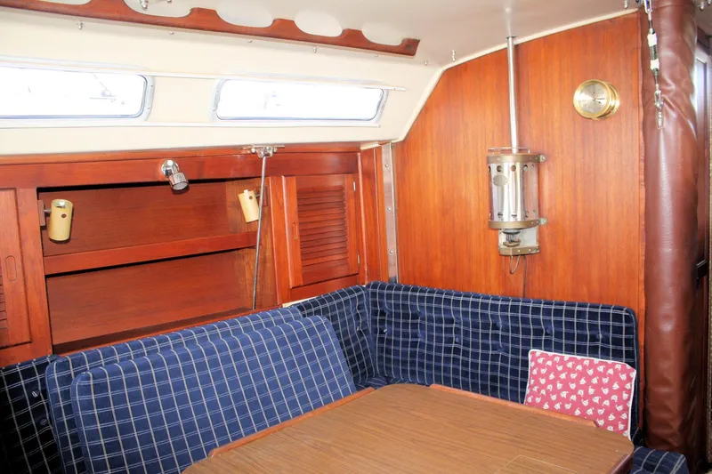Slide: The Image of Interior of 1986 Catalina 36 sailboat with wooden cabinetry and blue checkered seating. - 59