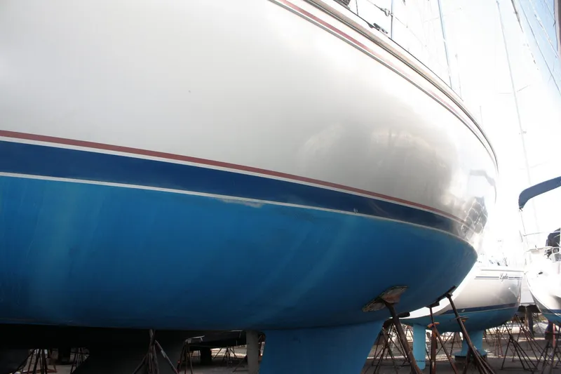 Slide: The Image of 1986 Catalina 36 sailboat hull in dry dock, showcasing blue and white exterior. - 6