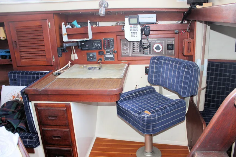Slide: The Image of 1986 Catalina 36 yacht interior with navigation station and blue plaid chair. - 60