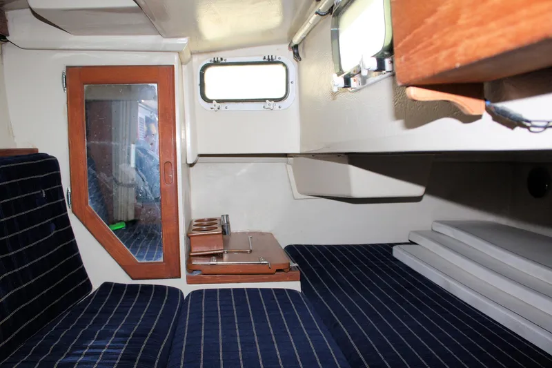 Slide: The Image of Interior of a 1986 Catalina 36 sailboat with striped seating and wooden accents. - 62