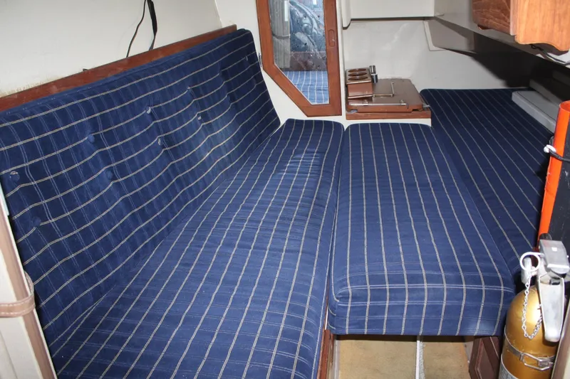 Slide: The Image of Interior cabin of a 1986 Catalina 36 sailboat with blue striped seating. - 63