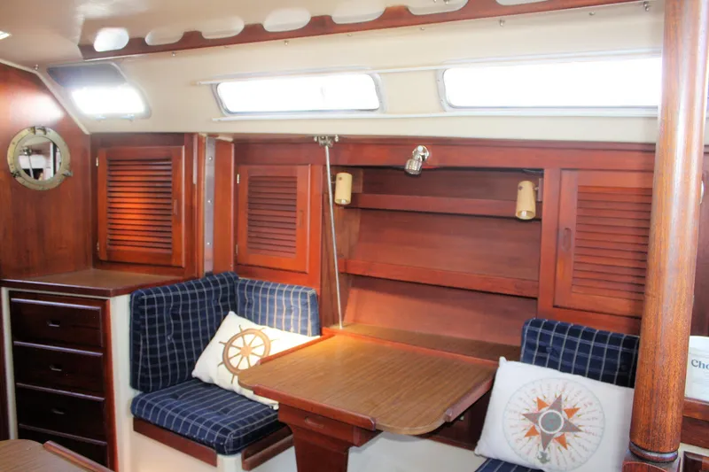 Slide: The Image of Interior of 1986 Catalina 36 sailboat with wooden cabinetry and nautical-themed cushions. - 78
