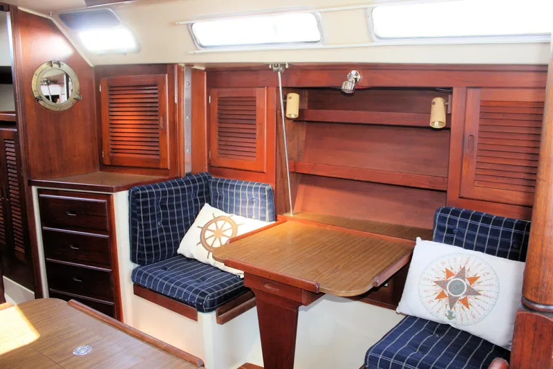 Slide: The Image of Interior of 1986 Catalina 36 sailboat with wooden cabinetry and blue cushioned seating. - 79