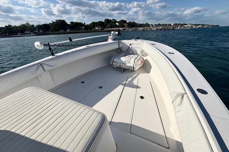 Slide: The Image of 2004 Regulator 26 Classic boat on calm water, featuring spacious deck and seating. - 8