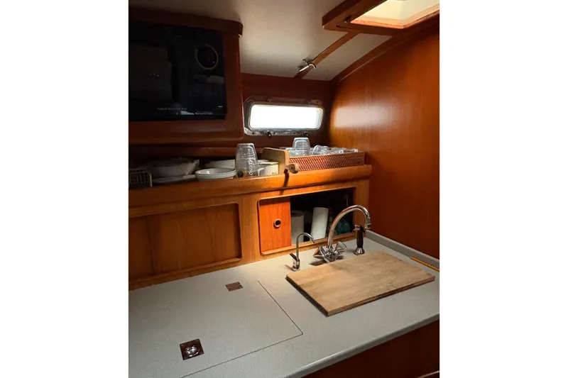 Slide: The Image of Little Harbor 36 yacht kitchen interior, featuring wooden cabinetry and a compact sink area. - 10