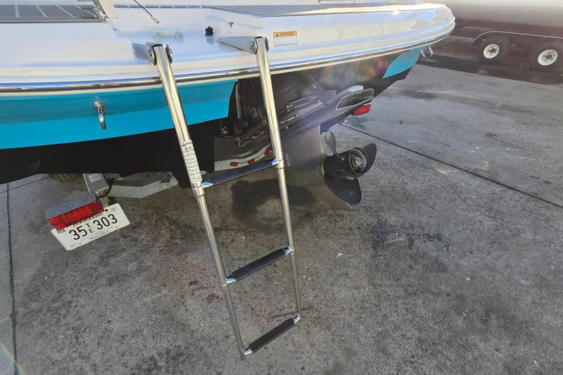 Slide: The Image of 2019 Regal 2000 ES Bowrider boat with ladder and propeller, parked on concrete. - 11