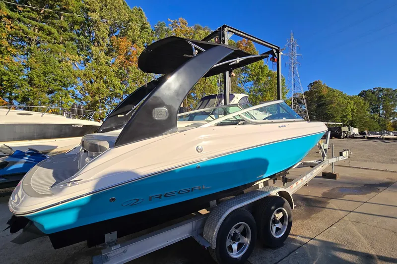 Slide: The Image of 2019 Regal 2000 ES Bowrider on trailer, vibrant blue hull, parked outdoors. - 12