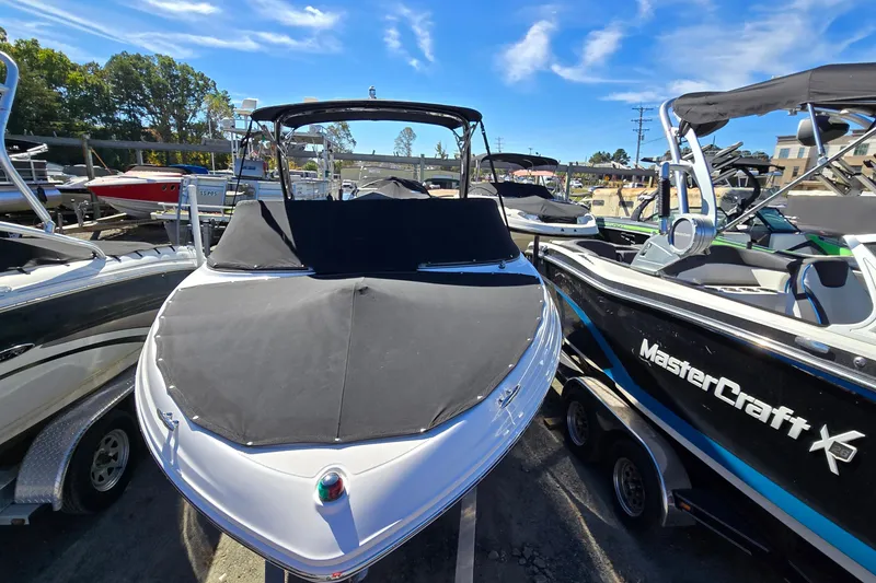 Slide: The Image of 2019 Regal 2000 ES Bowrider boat with cover, docked alongside other boats. - 14