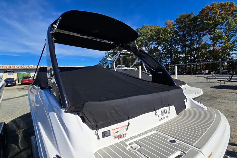 Slide: The Image of 2019 Regal 2000 ES Bowrider with black cover, parked outdoors under clear blue sky. - 15
