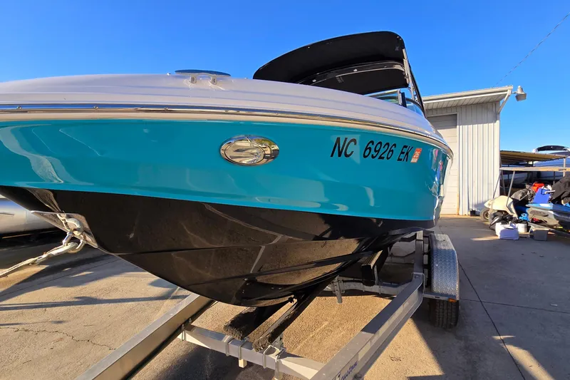 Slide: The Image of 2019 Regal 2000 ES Bowrider on trailer, vibrant blue hull, sunny day. - 4