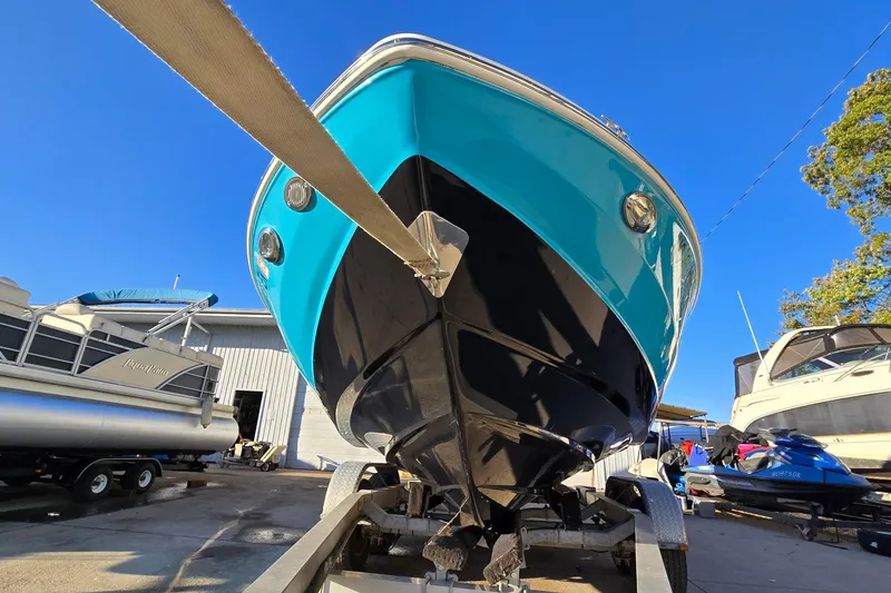 Slide: The Image of 2019 Regal 2000 ES Bowrider on trailer, vibrant blue hull, sunny day. - 5
