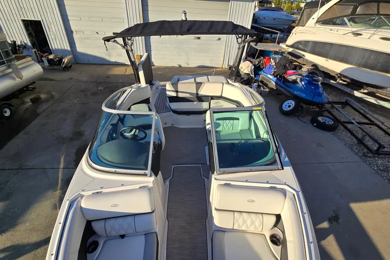 Slide: The Image of 2019 Regal 2000 ES Bowrider boat with canopy, parked near other watercraft. - 54