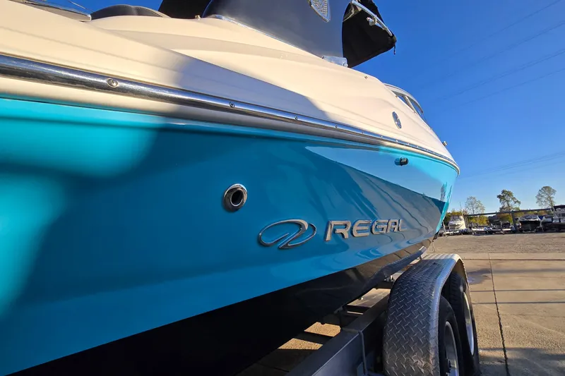 Slide: The Image of 2019 Regal 2000 ES Bowrider boat on trailer, blue hull, sunny day. - 7