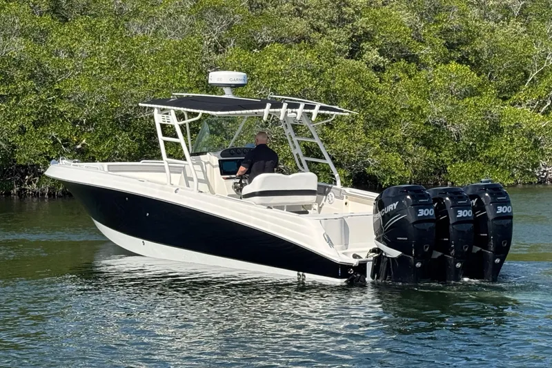 The Image of 2014 Wellcraft 35 Scarab Tournament boat with triple Mercury engines on calm water. - 1