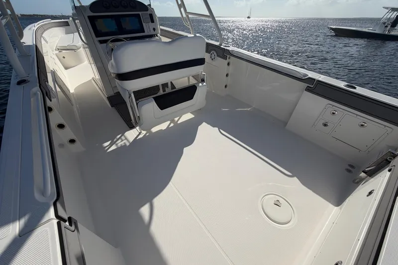 Slide: The Image of 2014 Wellcraft 35 Scarab Tournament boat interior with helm and seating, on calm water. - 16