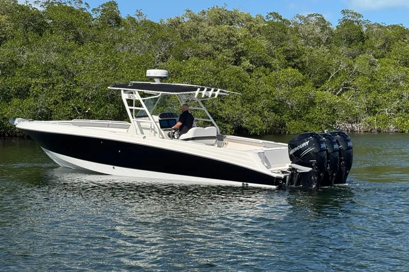 Slide: The Image of 2014 Wellcraft 35 Scarab Tournament boat with triple Mercury engines on a calm waterway. - 4