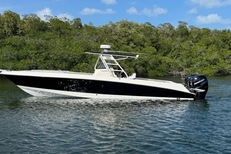 Slide: The Image of 2014 Wellcraft 35 Scarab Tournament boat on water, surrounded by lush greenery. - 5