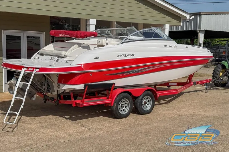 Slide: The Image of 2008 Four Winns F224 boat in red and white on a trailer, parked outdoors. - 19