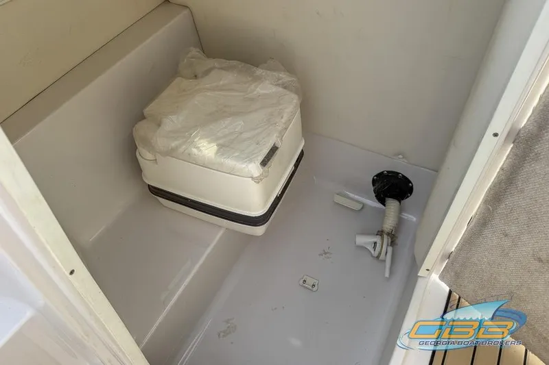 Slide: The Image of 2008 Four Winns F224 boat interior with portable toilet and plumbing fixtures. - 25