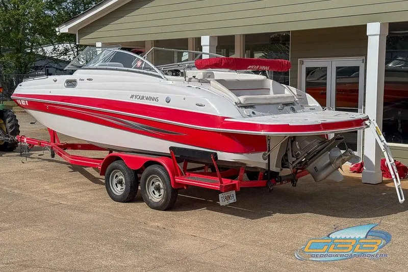 Slide: The Image of 2008 Four Winns F224 boat on red trailer, parked outside a building. - 4