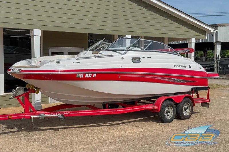 Slide: The Image of 2008 Four Winns F224 boat on red trailer, parked outside a building. - 6
