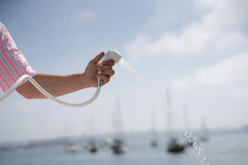 Slide: The Image of Manufacturer Provided Image: Hand holding a hose spraying water, with boats in the background. Tide Craft Galveston 19, 2025. - 11