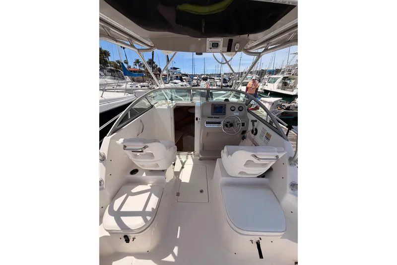 Slide: The Image of 2008 Robalo R225 Walkaround boat interior with helm, seating, and marina view. - 10
