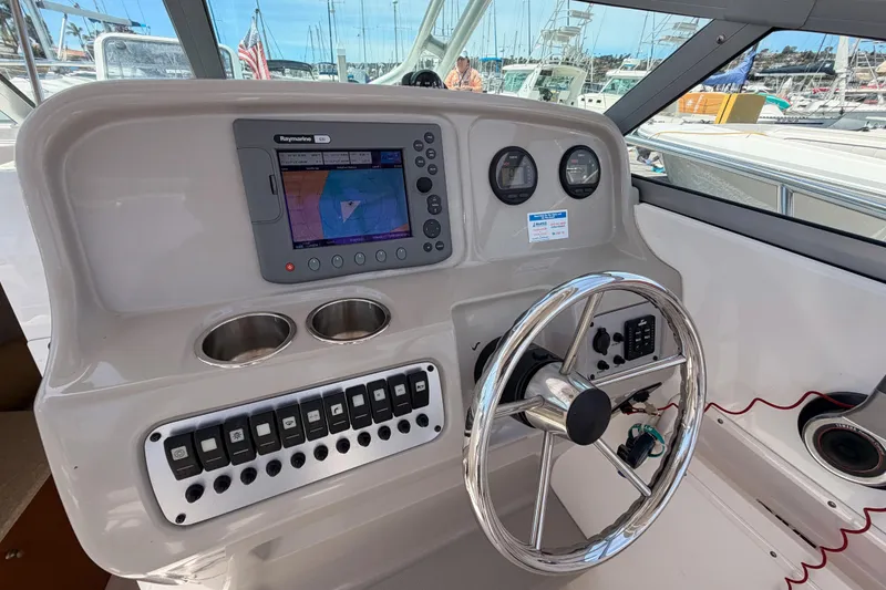 Slide: The Image of 2008 Robalo R225 Walkaround helm with navigation system and steering wheel in marina setting. - 14