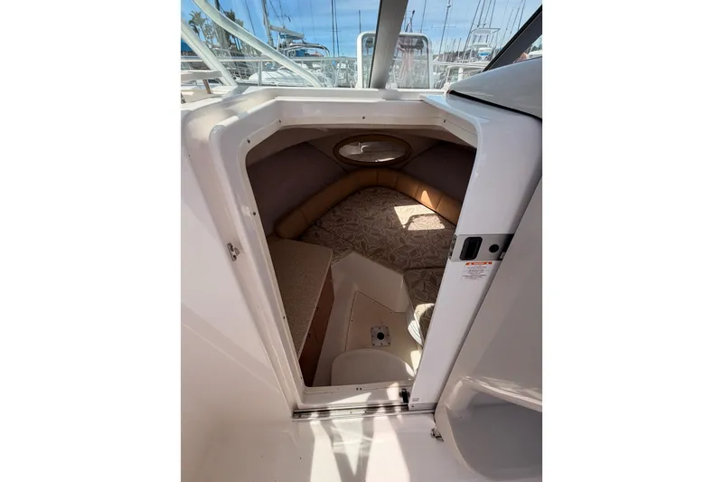 Slide: The Image of 2008 Robalo R225 Walkaround cabin interior with cushioned seating and porthole window. - 18